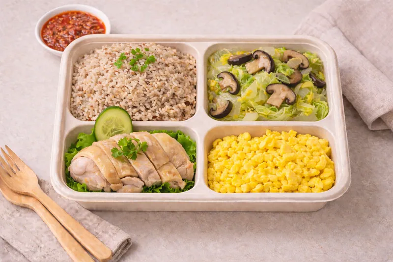 Healthier choice halal vegan bento with mixed brown rice, plant based curry vegetables, tofu and seasonal greens