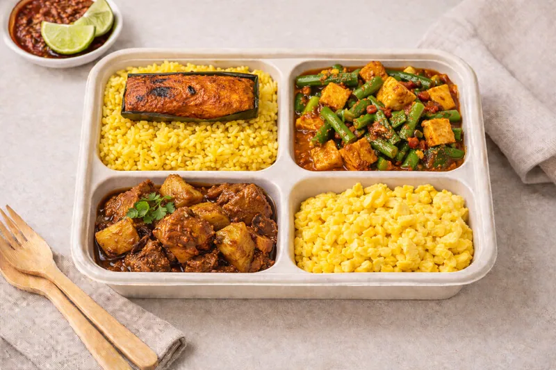 Healthier choice halal bento with wholegrain nasi kuning, sambal goreng longbean, chicken rendang, egg and grilled fish otah
