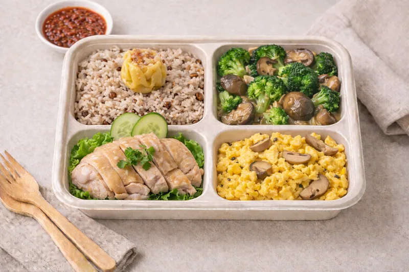Healthier choice halal bento with wholegrain chicken rice, braised broccoli with straw mushroom, Hainan chicken, egg and shiitake chicken siew mai